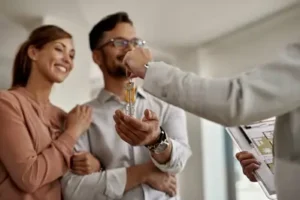 Real Estate Agent Giving Keys To New Homeowners